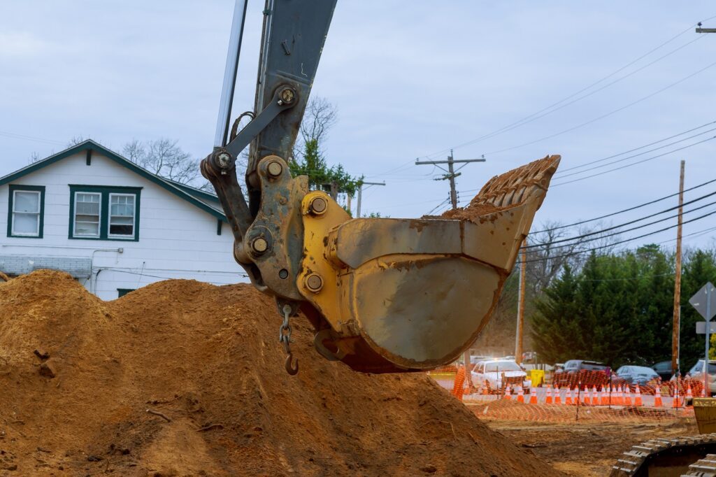 Septic System repair - house under construction foundation with excavator shovel a septic tank sewerage construction